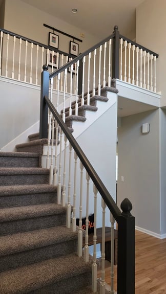 Dark stained staircase railing and banister with white painted rods.