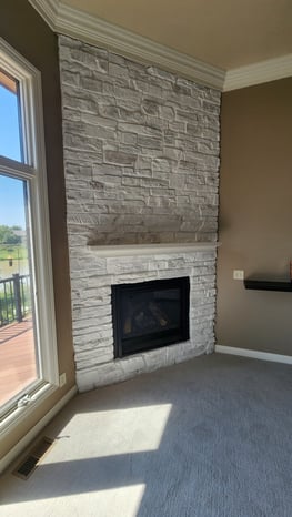 Fireplace stone painted white in the corner of a living room.