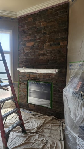 Stone brick fireplace in a dark brown color inside of a living room in a home in Omaha, NE.
