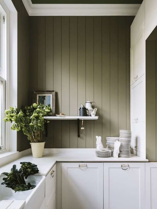 Sage green kitchen walls with white cabinetry