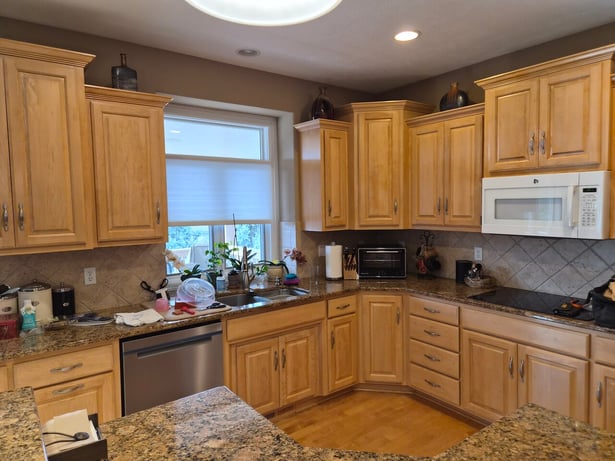 Kitchen cabinets with a clear coat over warm light wood doors.