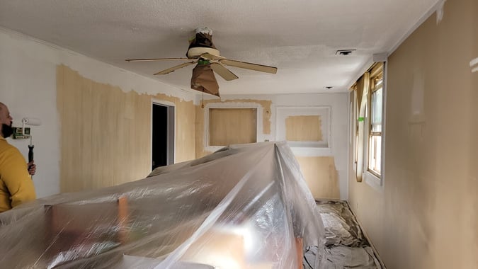 Room with board walls in the process of being painted.