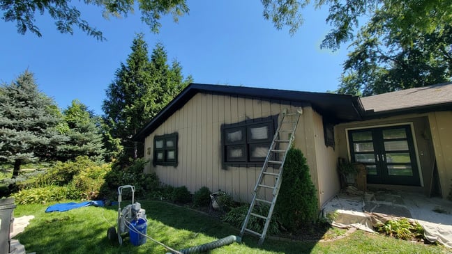 Exterior windows in the process of being sprayed black.