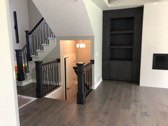 Descending and ascending staircase railings and banisters in a home painted black with black rods.