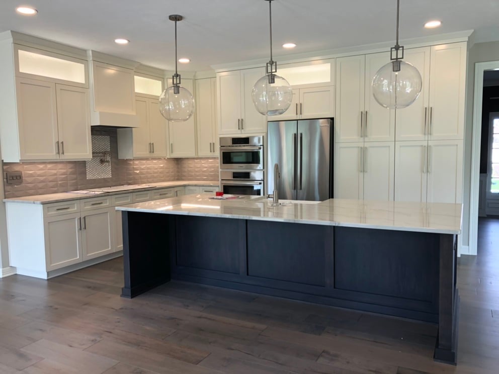 Kitchen with white painted cabinets and a darker painted island.