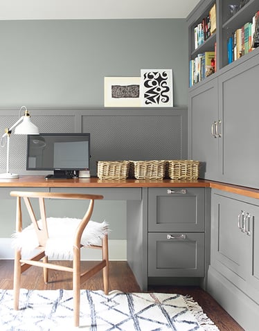 Home office with grey cabinets and eggshell finish on walls.