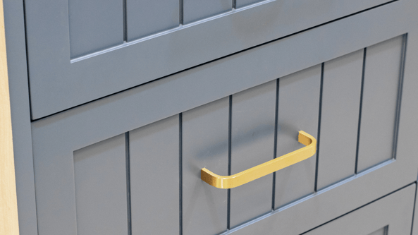 Close up of cabinet drawer painted a dark navy blue with brass gold handles.