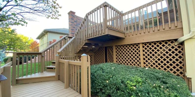 Deck with large staircase stained a light golden wood tone.