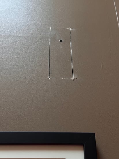 Drywall cut into a square on a wall in Omaha NE before fixing and painting.