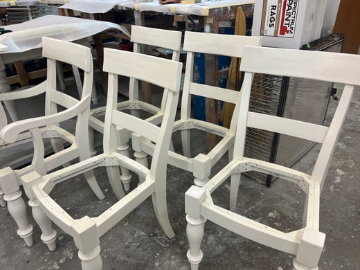 Set of wood chairs with white primer sprayed on them before painting in Omaha.