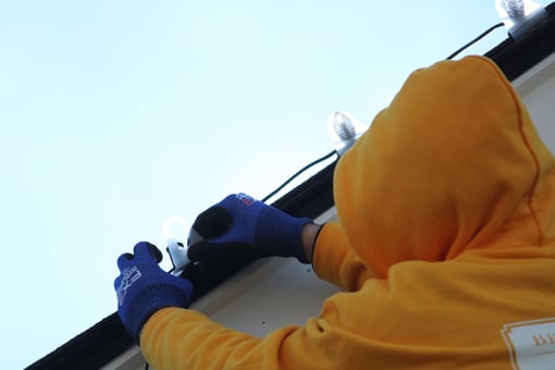Brush & Roll painting painter installing christmas lights on the roofline of a home in Papillion.