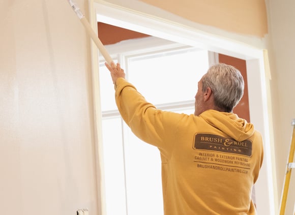 Brush & Roll Painting Painter rolling white paint onto wall inside of a home in Omaha, NE.