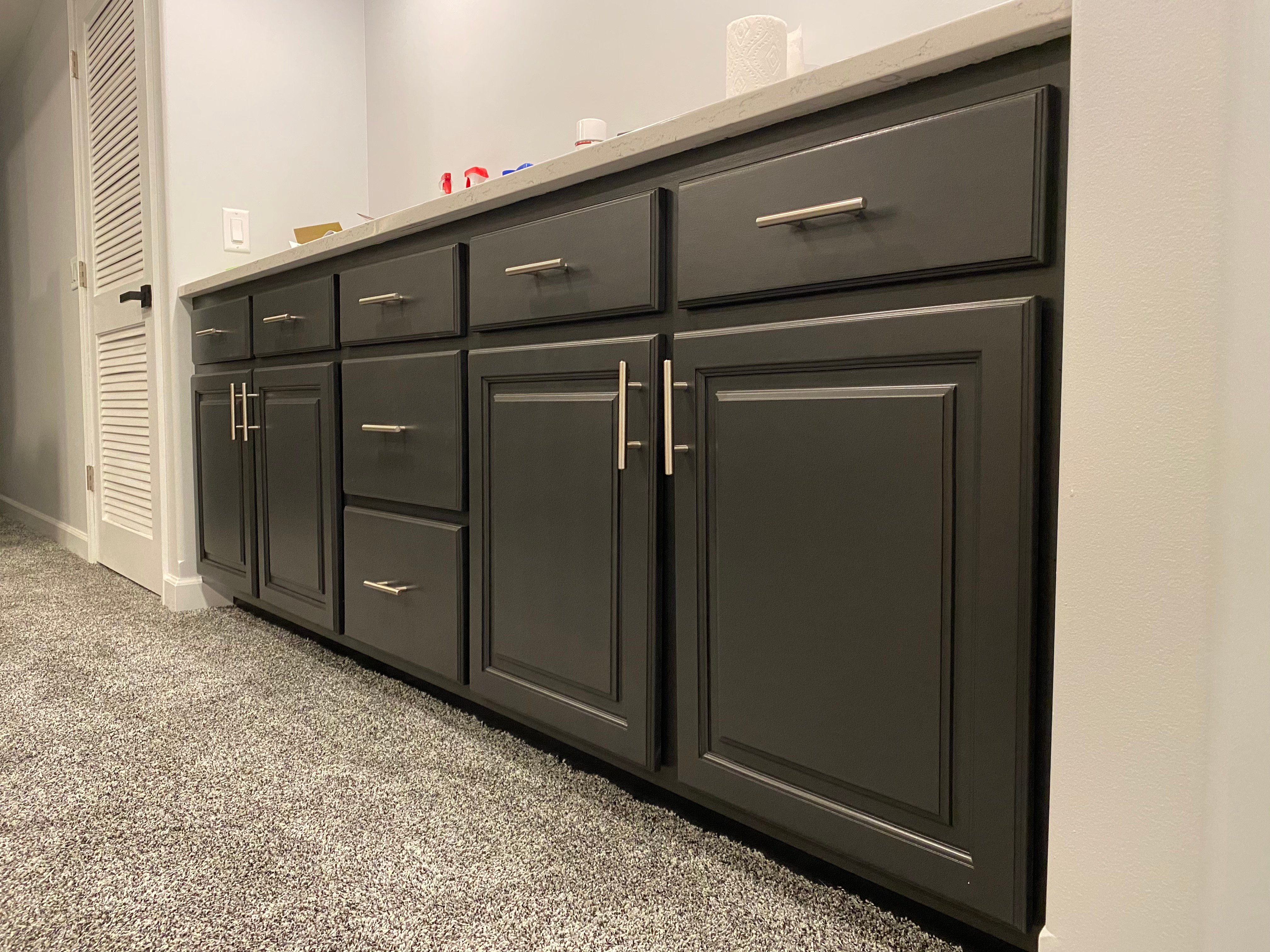 Lower cabinets painted black with silver handles in a basement kitchen in Omaha, NE.