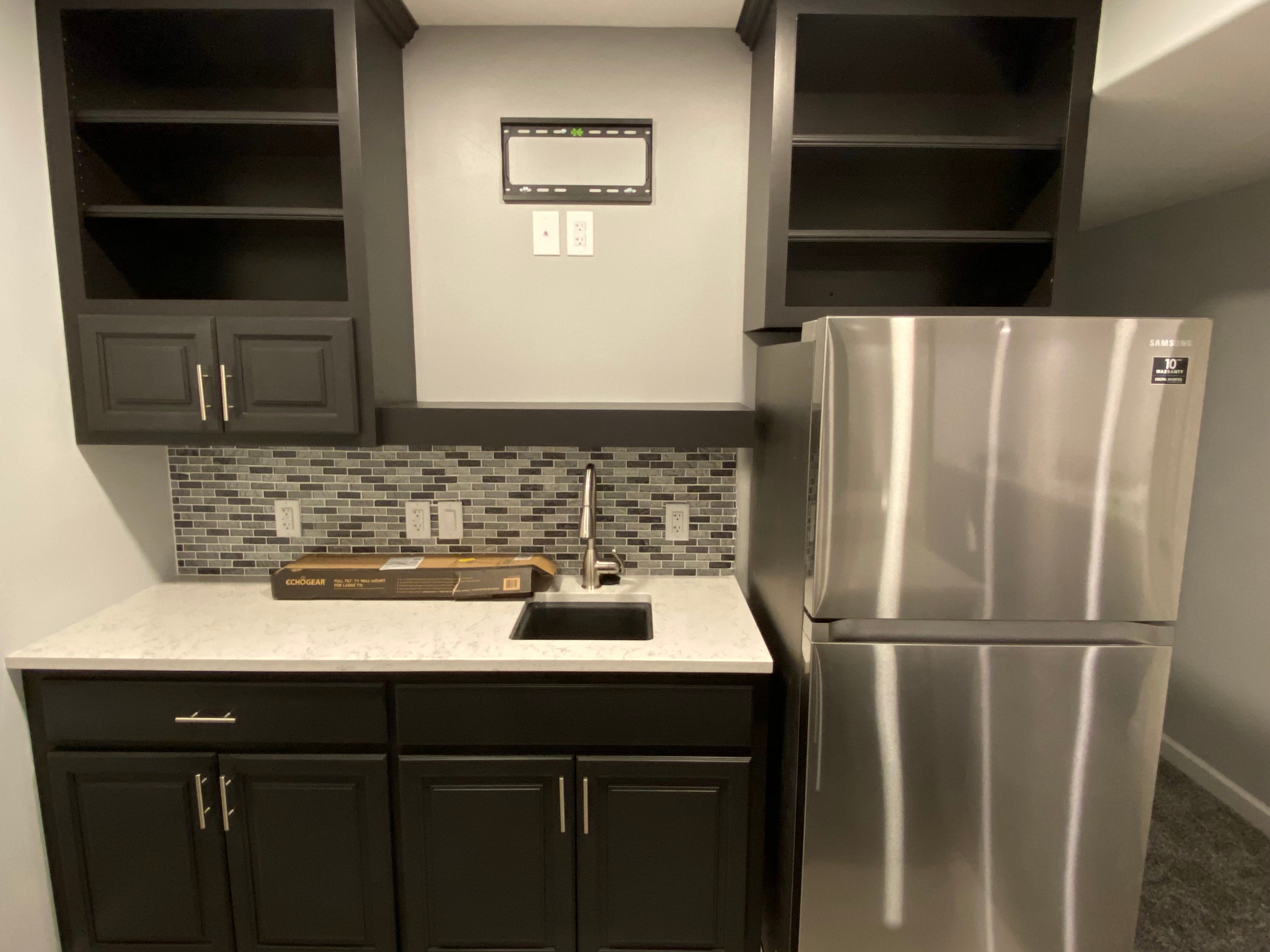 Basement kitchen with a fresh black paint color and smooth finish on cabinets in a home in Omaha, nE.