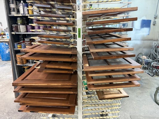 Cabinet doors and drawer fronts on a rack inside a shop for cabinet painting in omaha, NE.