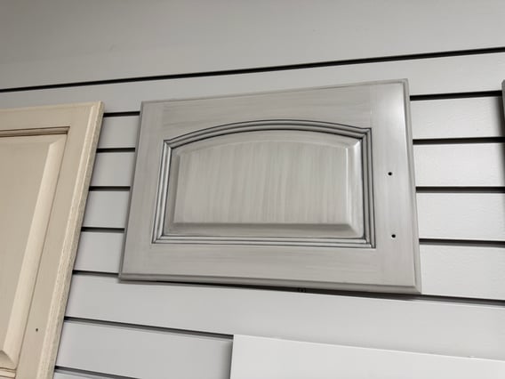 Cabinet door with a brushed grey glaze on a white painted drawer.