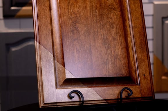 Dark wood cabinet door being stained into a warm redish toned door in omaha, NE for kitchen cabinets.