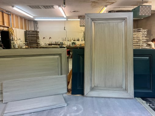 Cabinet doors and drawer fronts that are painted white with a light grey glaze overtop.