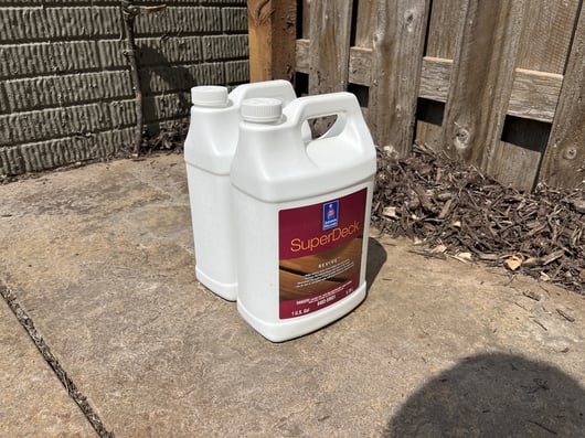 Sherwin Williams Super Deck product outside on the concrete, for painters to use to clean a wooden deck and fence