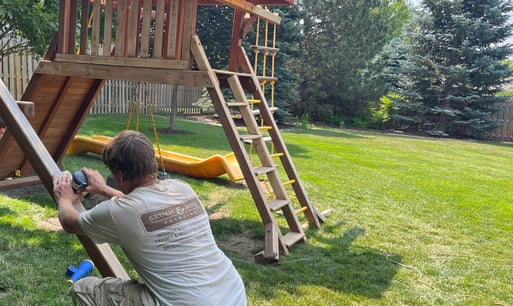 Brush & Roll Painting painter sanding a wooden playground before staining.