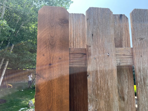 Fence boards before and after staining.