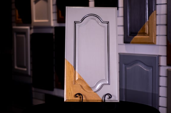 Golden oak door painted with a beige solid paint color and pinstriped with a dark stain in the detailed frame.