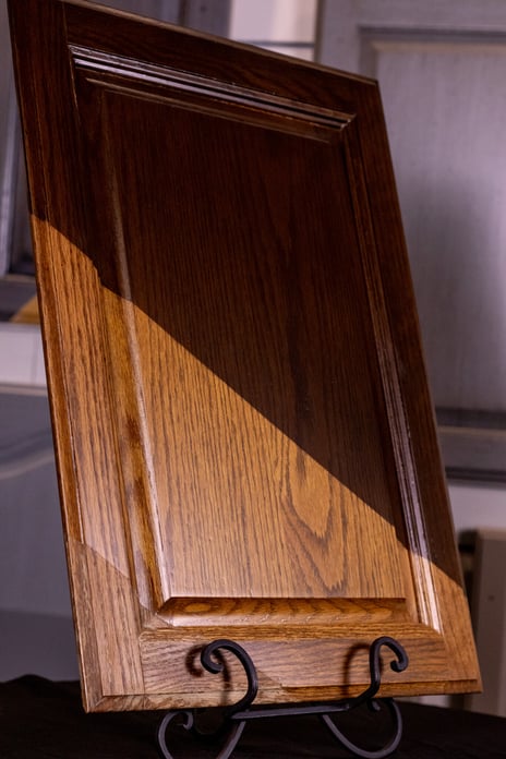 Cabinet door showing before and after of cabinet staining with a 2k polyurethane.