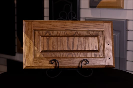Stained cabinet door showing before and after staining oak.