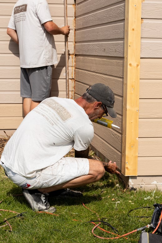 Outside corner of exterior of house with new siding board replaced before painting in Omaha, NE.