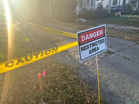 "Danger Protected Area" sign with caution tape around exterior of house with lead paint being removed.