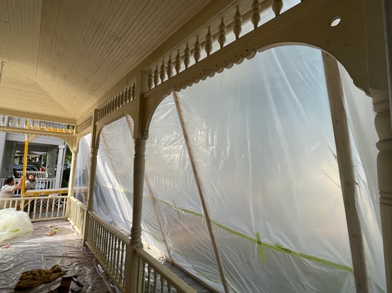 Front porch of a home guarded off with a board structure and plastic.