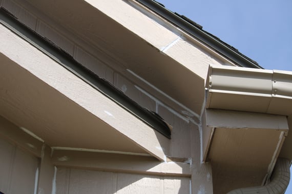 Corner of a home with caulk in between baps to prevent water damage on a home before painting.