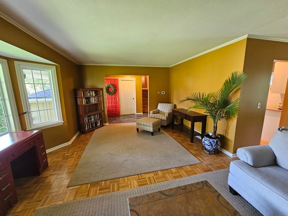 Living room freshly painted a mustard yellow color on walls with white woodwork.