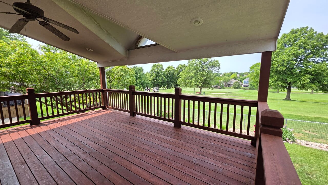 Deck after being stained on the backside of a 3 story home in Gretna, NE in a redish tone transparent stain.