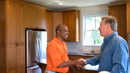 Homeowner shaking hands with local sales estimator.