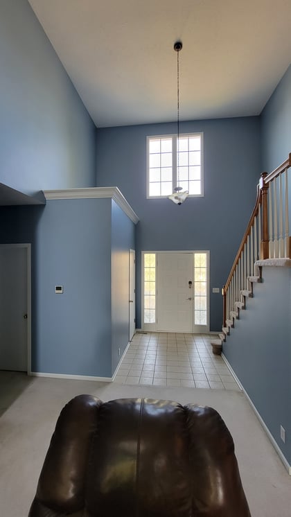Entryway with light blue painted walls and a white ceiling with white woodwork.