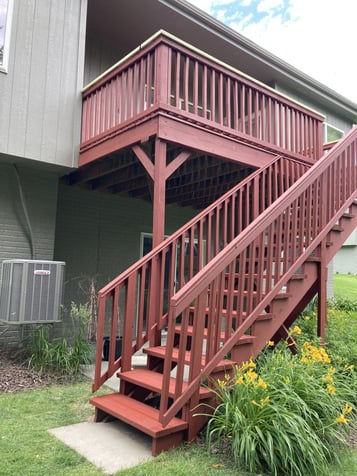 Wooden deck with stairs, stained a deep red solid stain.