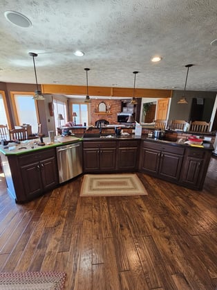 Dark wood cabinets on a island and dark wood floors.