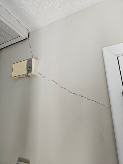 Crack on a wall painted light brown inside a home in Omaha, NE.