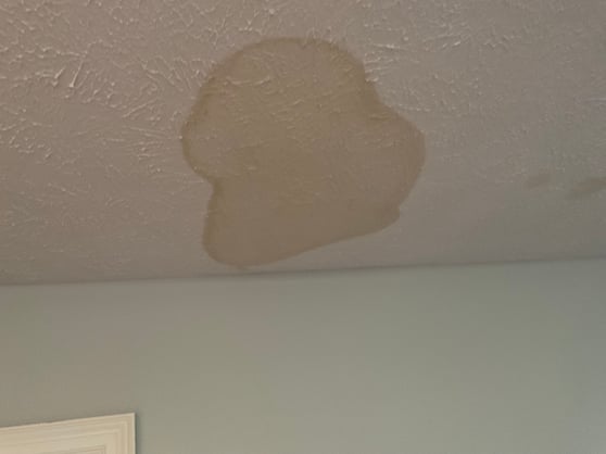 Ceiling water stain on a ceiling painted white inside a bedroom in Omaha, NE.