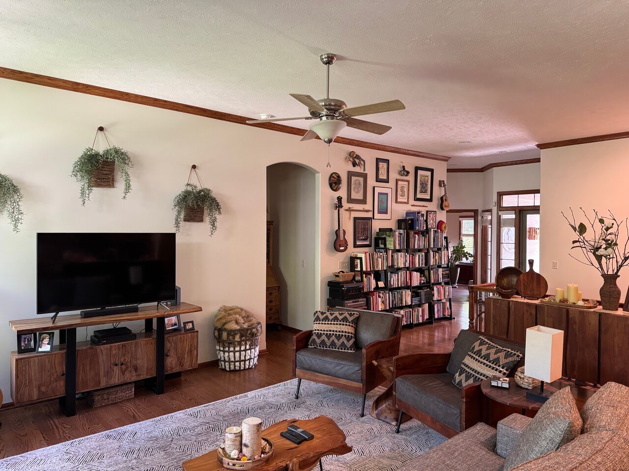 Living room painted white on walls and ceiling with wood trim and with plants and decor.