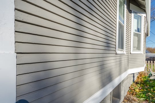 Exterior of house with light grey color and white trim.