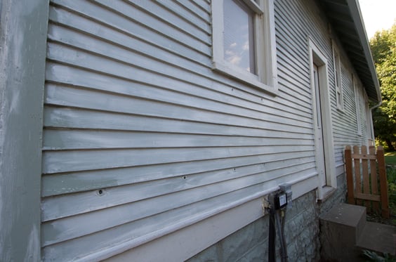 House that has faded and the siding is damaged.