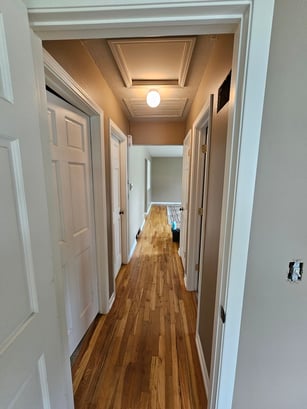 Hallway with many interior doors and trim painted white.