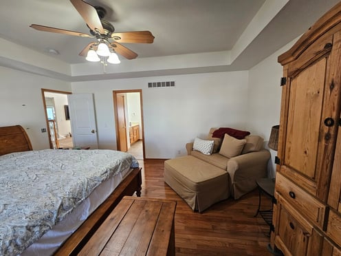 Bedroom with white walls and brown woodwork trim.
