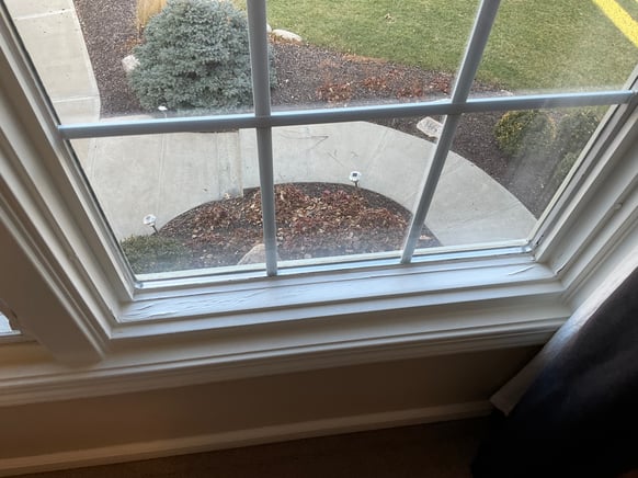 Cracked paint on a window inside a home.