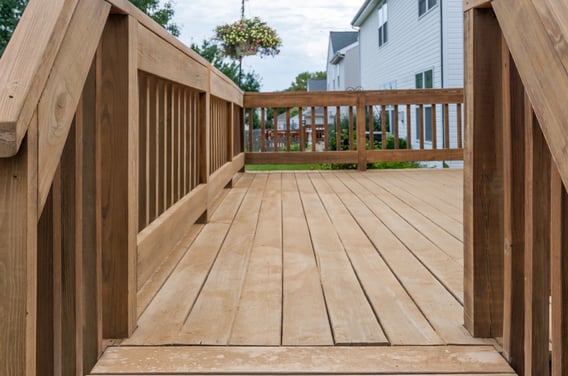 Wood deck unstained with patches and fading.