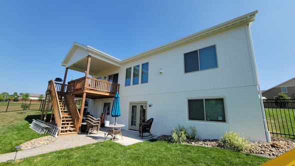 Exterior house painted white with a warm brown stained deck.
