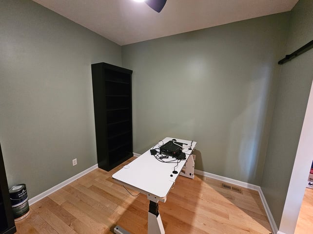Office interior painted walls a sage green color and trim is painted white.