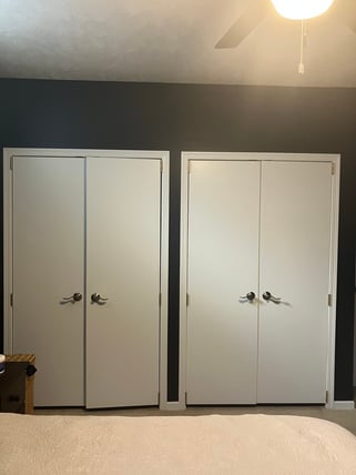 Interior bedroom with black painted walls with white door trim and white ceiling.